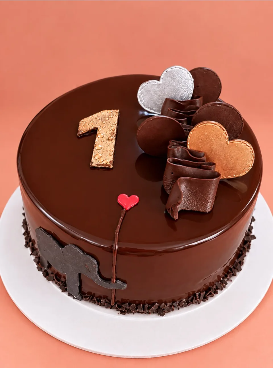 Torta de chocolate con glaseado espejo, topper dorado número uno y corazones de chocolate